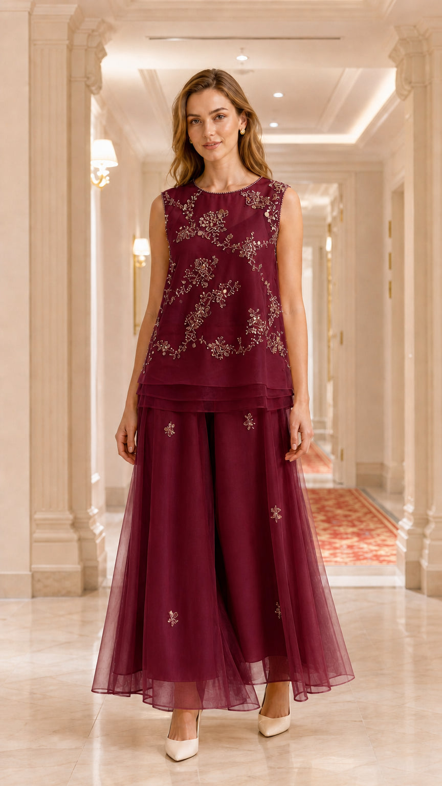 Model wearing burgundy wine embroidered sleeveless tunic and wide-leg pant set