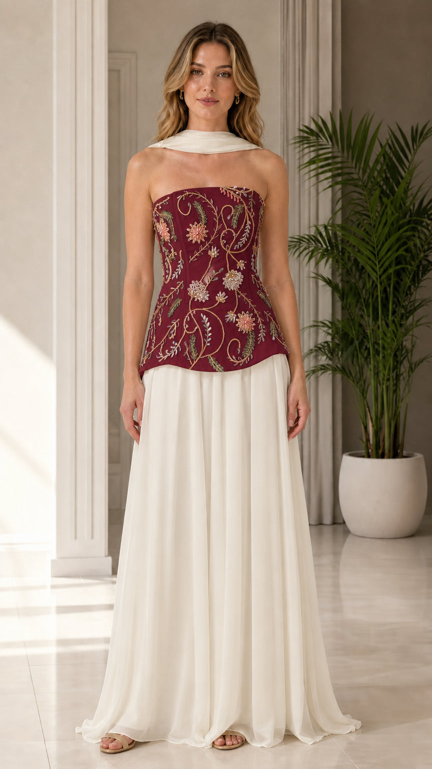 Model wearing burgundy wine floral beaded corset top with ivory sweeping evening skirt
