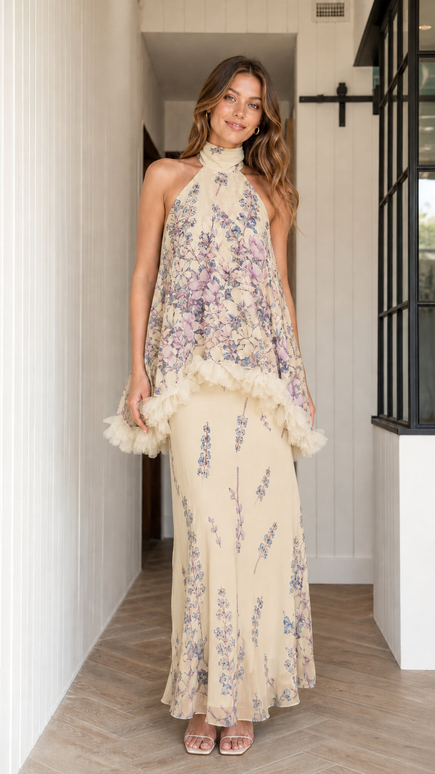 Model wearing champagne floral halter maxi dress with ruffle overlay