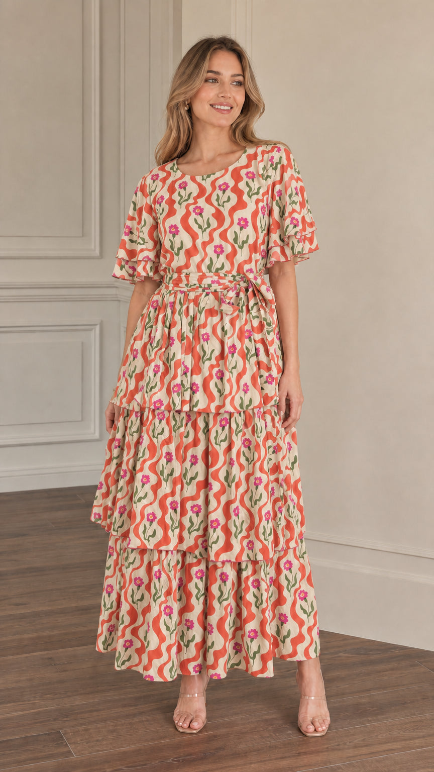 Front view of model wearing orange floral wave print tiered maxi dress