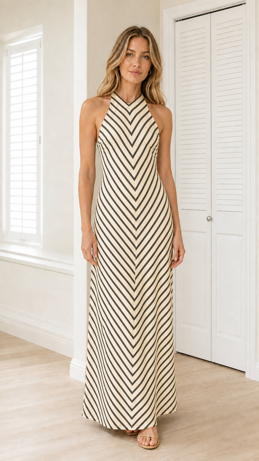 Front view of model wearing beige striped halter maxi dress