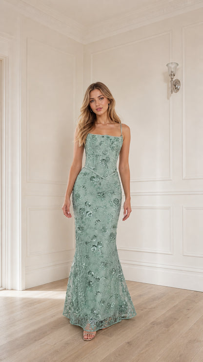 Woman wearing sage green sequin embroidered corset maxi dress, front view