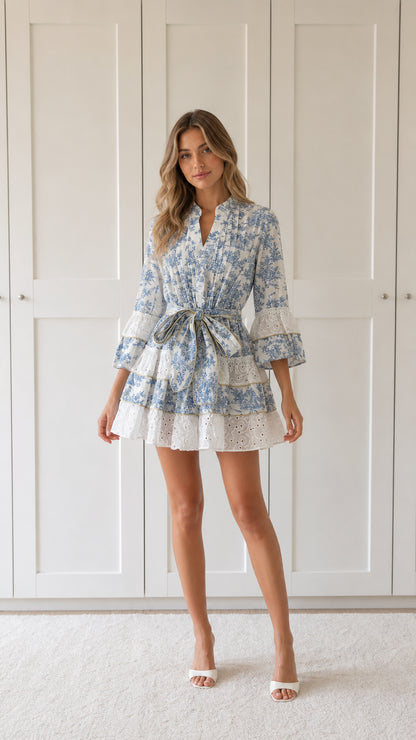 Front view of woman wearing blue floral print ruffle mini dress