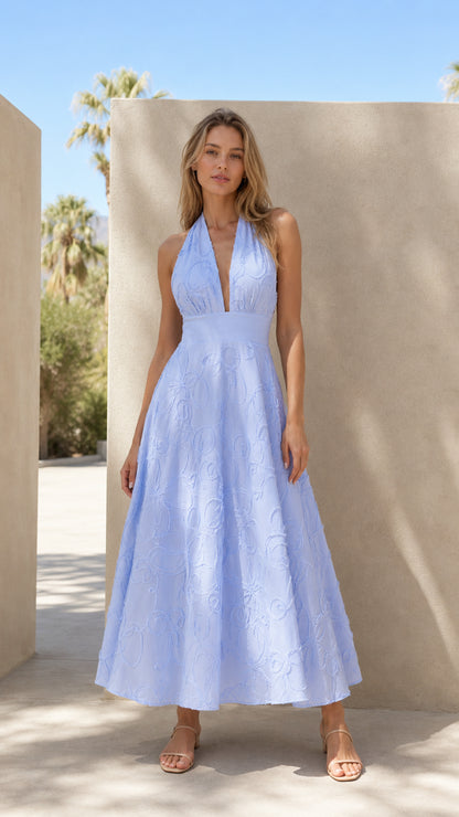 Front view of model wearing light blue textured halter neck maxi dress