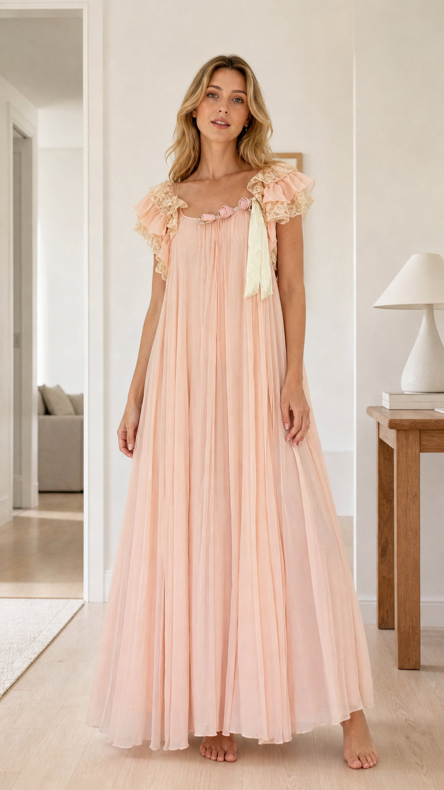 Full front view of model wearing a flowing blush pink pleated maxi nightgown with lace flutter sleeves