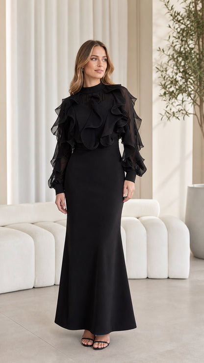 Front view of woman wearing elegant black ruffled long-sleeve maxi dress
