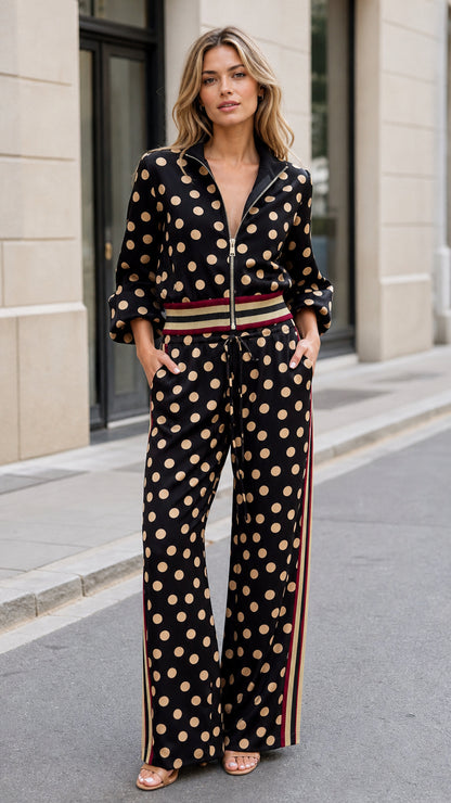 Front full view of woman wearing black polka dot two-piece jacket and wide-leg pant set