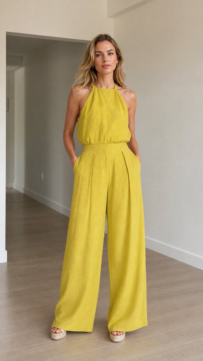 Model wearing yellow halter neck wide-leg jumpsuit front view