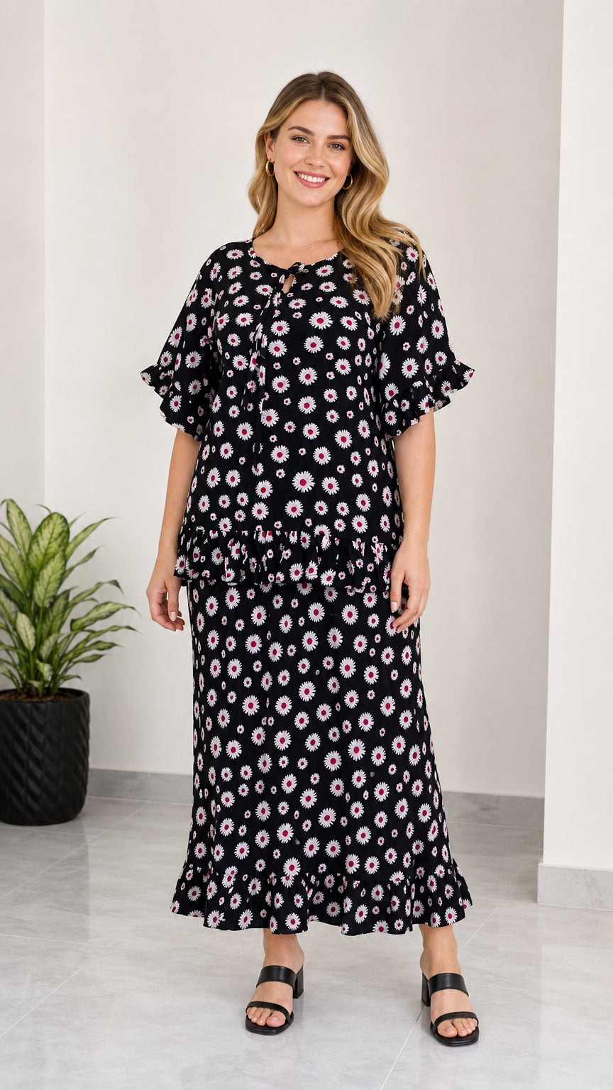 Full front view of women's black floral print tie-neck top and ruffle maxi skirt two-piece set