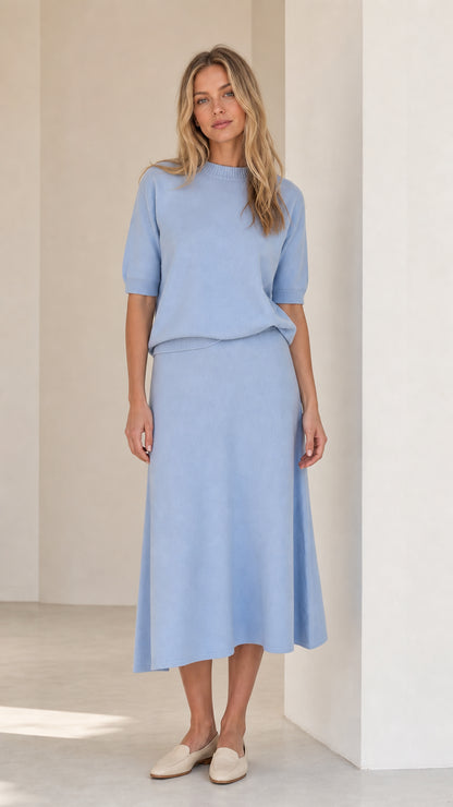 Front view of woman wearing light blue knit top and matching midi skirt set