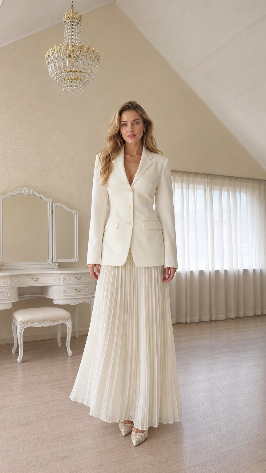 Full length view of a woman wearing a white tailored blazer and pleated skirt
