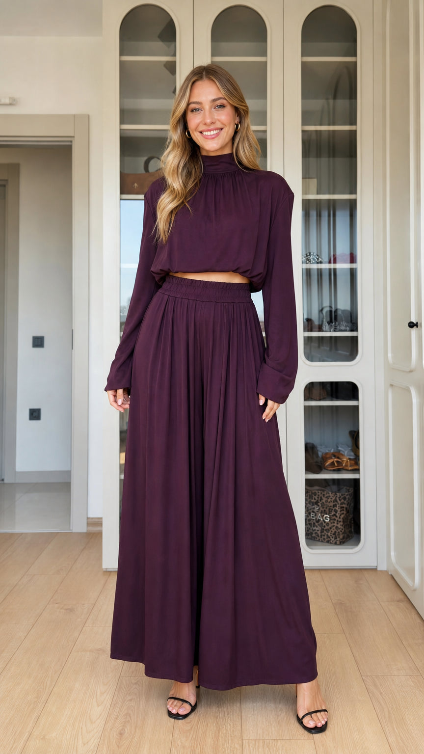 Front full-length view of woman wearing plum mock neck crop top and matching pleated wide-leg pants
