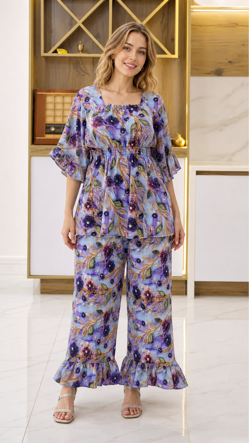 Front view of woman wearing Periwinkle Blue floral 2-piece smocked top and ruffle wide-leg pant set