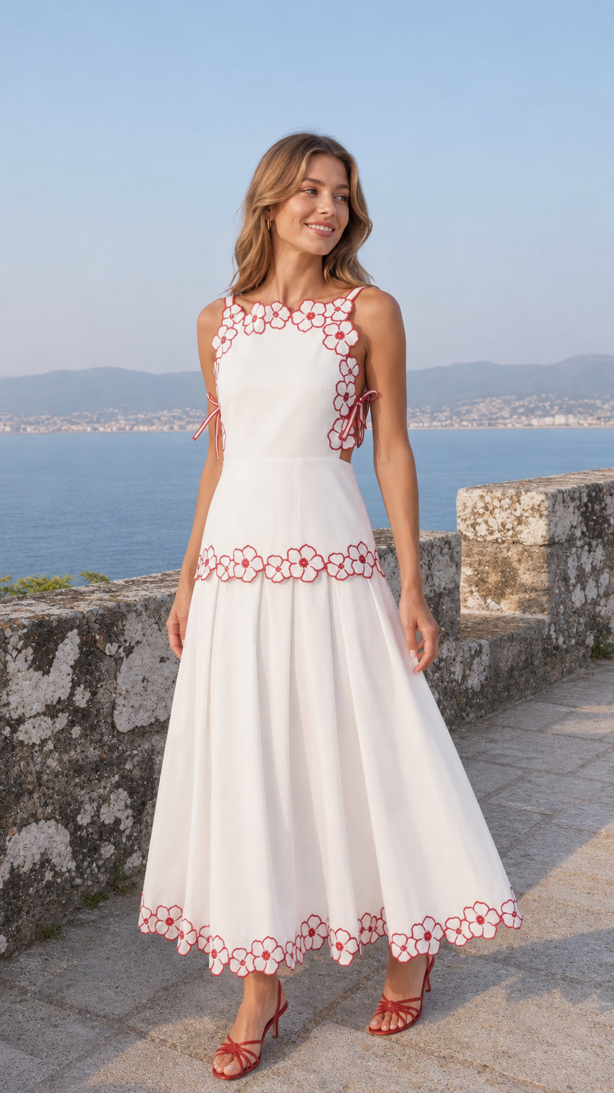 Front view of woman wearing white embroidered floral midi dress by the coast