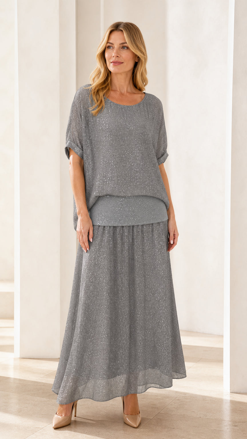 Front view of model wearing grey shimmer two-piece maxi skirt set