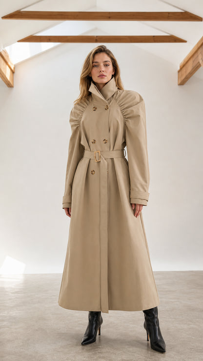 Front full-length view of woman wearing beige ruched shoulder maxi trench coat