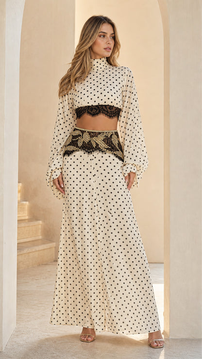 Cream polka dot two-piece set featuring long sleeve mock neck crop top with lace trim and matching maxi skirt front view
