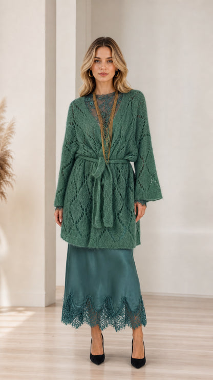 Model wearing green open front knit cardigan with belt, front view