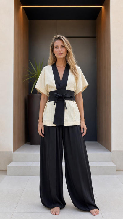 Front view of woman wearing beige kimono top and black wide-leg pants set