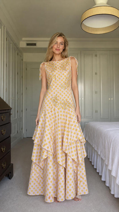 Front view of model wearing yellow polka dot tiered maxi dress