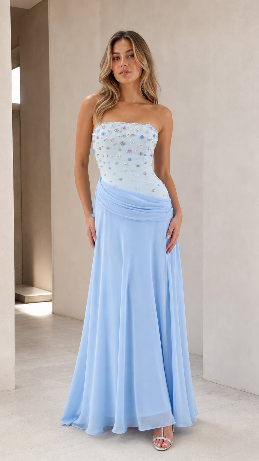 Front view of model wearing sky blue strapless floral beaded floor length evening gown