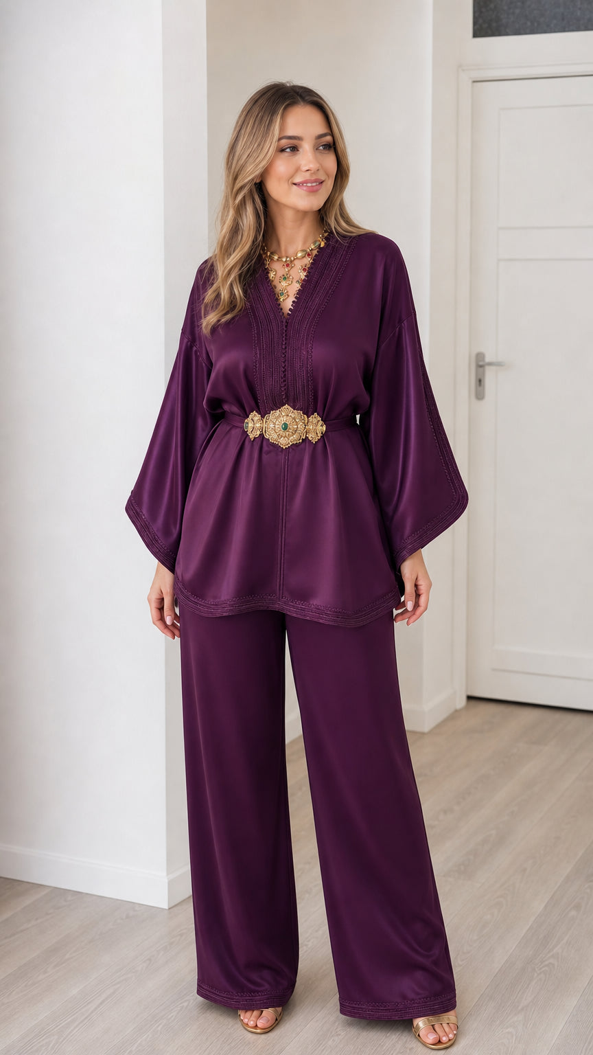 Front view of woman wearing deep purple embroidered satin kaftan tunic and wide leg pants set with belt