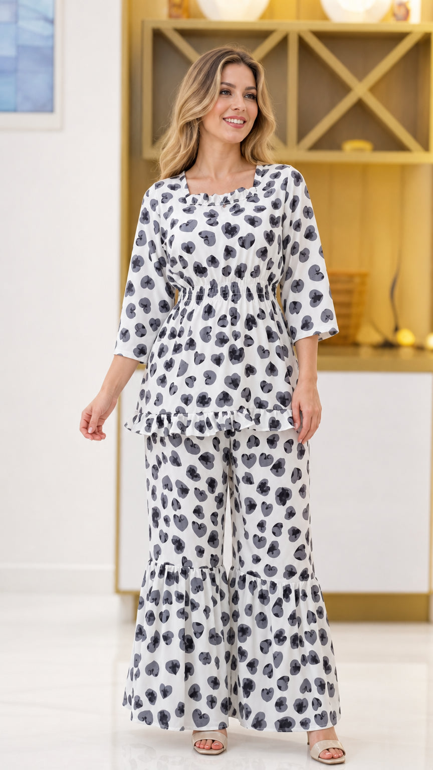 Front view of woman wearing white floral print 2-piece set with smocked top and tiered wide leg pants