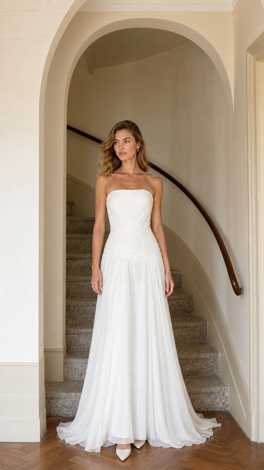 Front view of model wearing strapless white drop waist pleated chiffon maxi gown