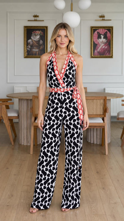 Front view of model wearing black and white abstract print halter jumpsuit