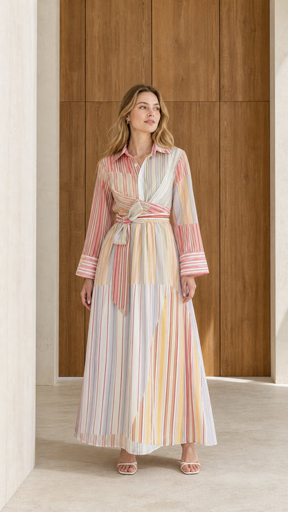 Front full-length view of model wearing pastel multi striped long sleeve maxi shirt dress with wrap tie waist