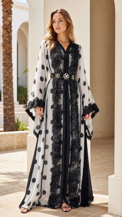 Full-length front view of woman wearing white polka dot maxi abaya with black lace trim and belt