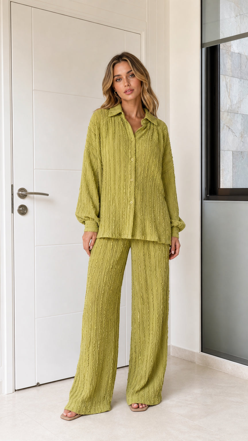 Front view of woman wearing olive green textured button-down shirt and wide-leg pants set