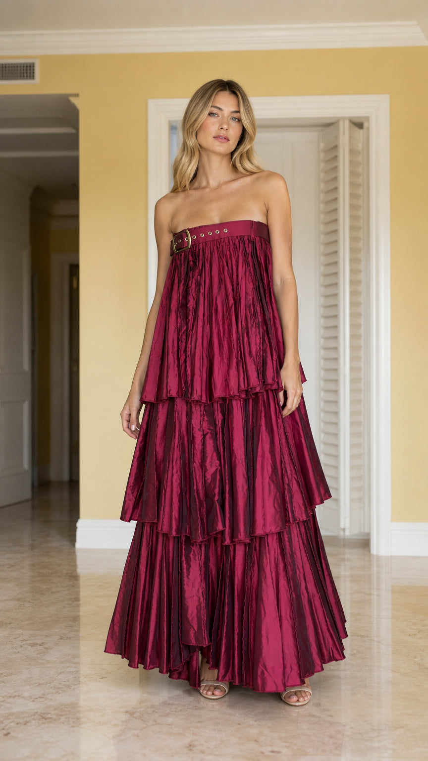 Full front view of model wearing burgundy strapless pleated tiered maxi dress with buckle detail