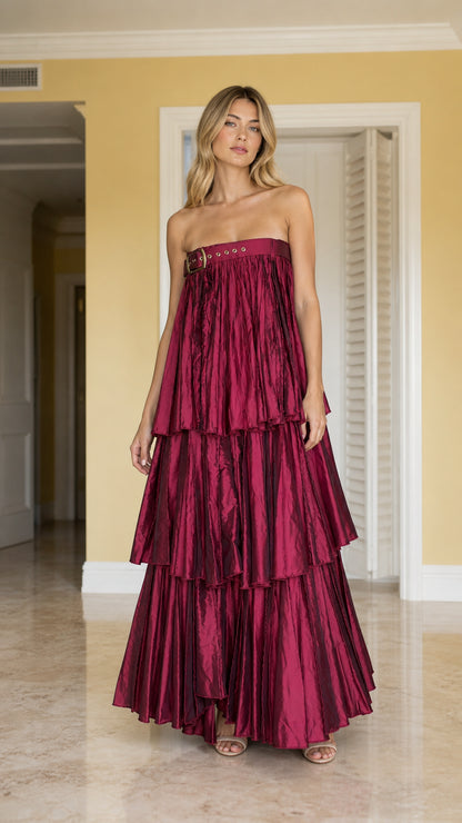 Full front view of model wearing burgundy strapless pleated tiered maxi dress with buckle detail