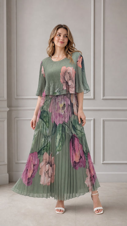 Full front view of model wearing sage green floral pleated maxi dress with layered overlay