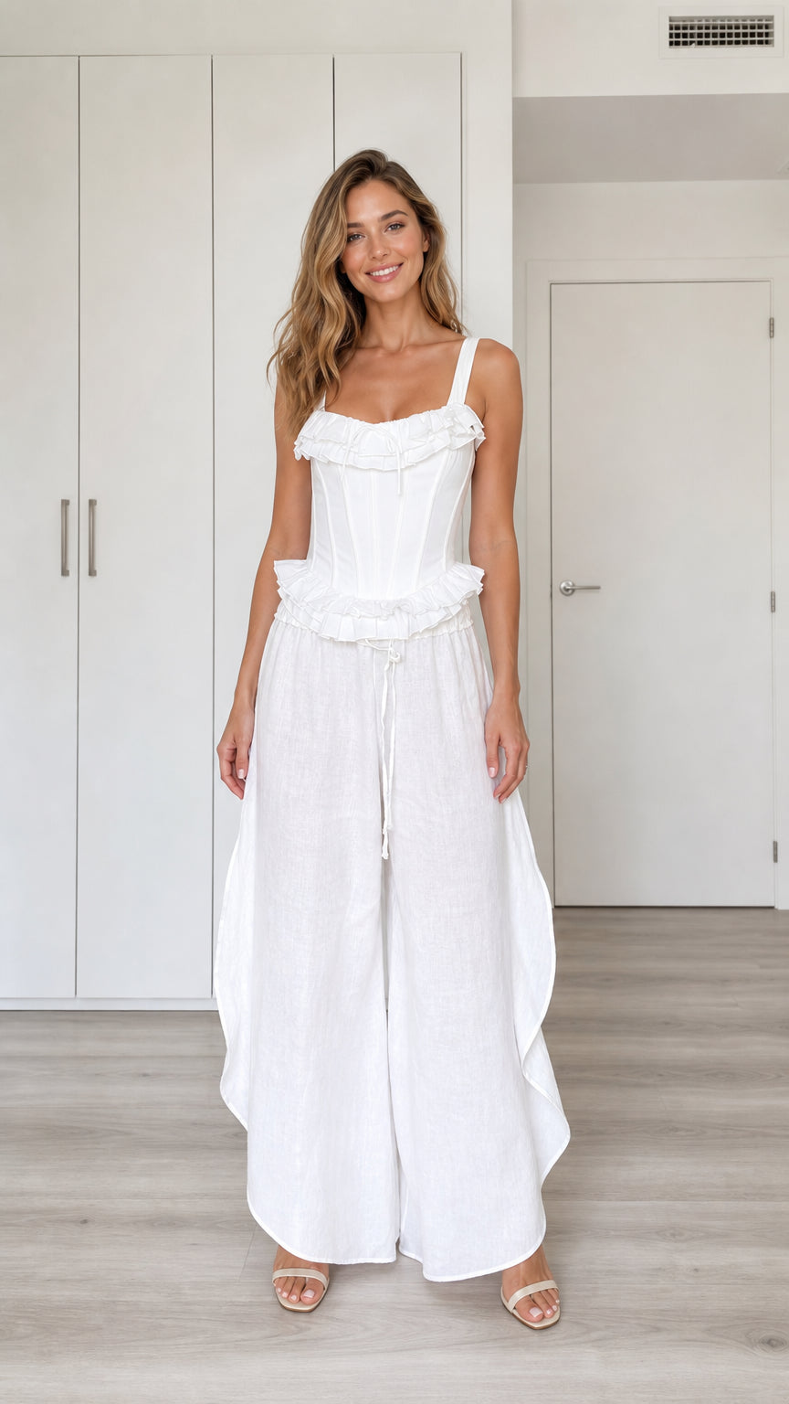 Model wearing white ruffled corset top and wide-leg pants set, front view