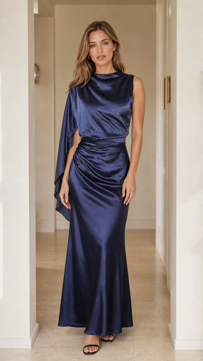 Full-length front view of woman wearing navy blue asymmetric cape sleeve satin maxi dress