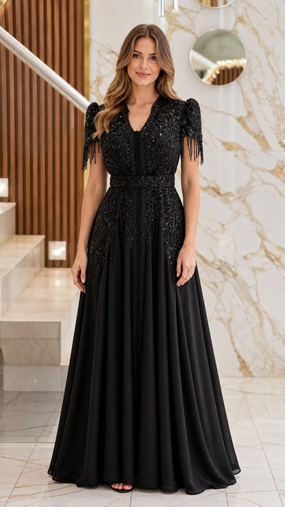 Full-length front view of model wearing the black beaded V-neck evening gown with fringe sleeves