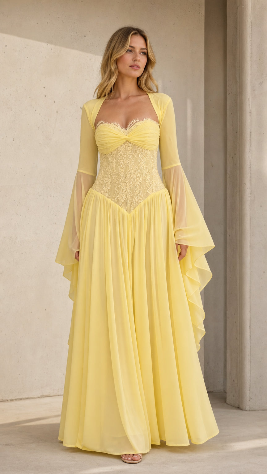 Front view of model wearing pale yellow lace corset maxi dress with bell sleeves