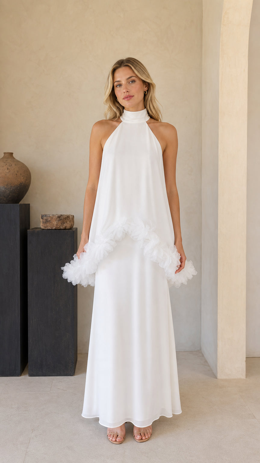Front view of model wearing white high-neck halter maxi dress with ruffle trim