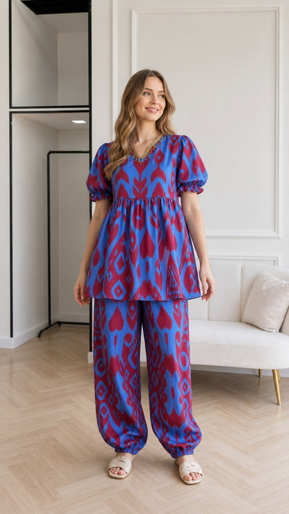 Front view of woman wearing Royal Blue ikat print babydoll top and matching cuffed pants