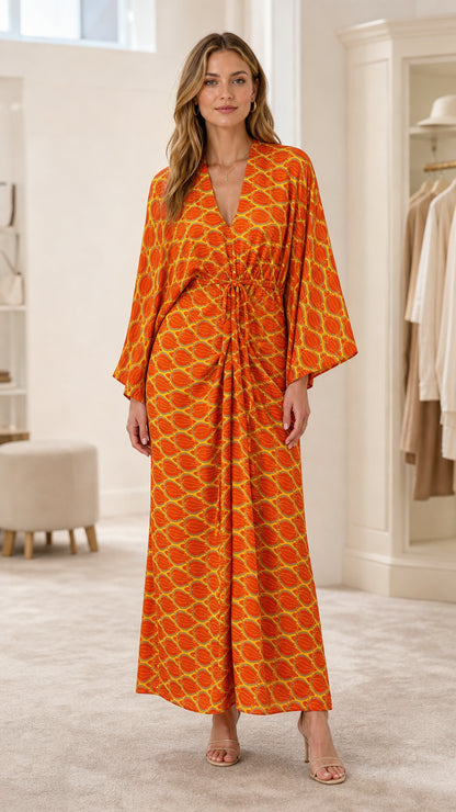 Front view of model wearing orange geometric print maxi dress