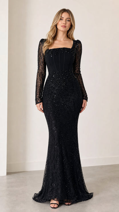 Full front view of model wearing black beaded long sleeve corset evening dress