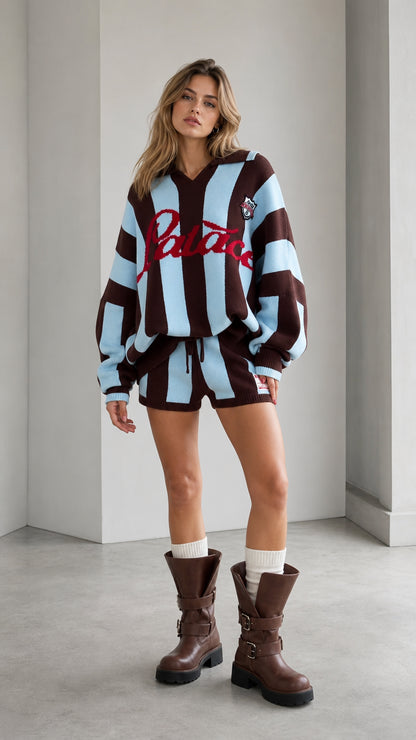 Front full-length view of model wearing brown and light blue striped knit polo and shorts set with boots