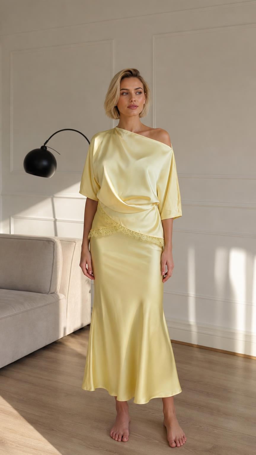 Woman wearing yellow satin asymmetrical top and midi skirt front view