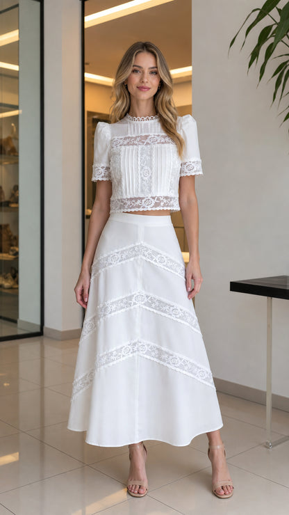 Front view of woman wearing white lace crop top and matching midi skirt set