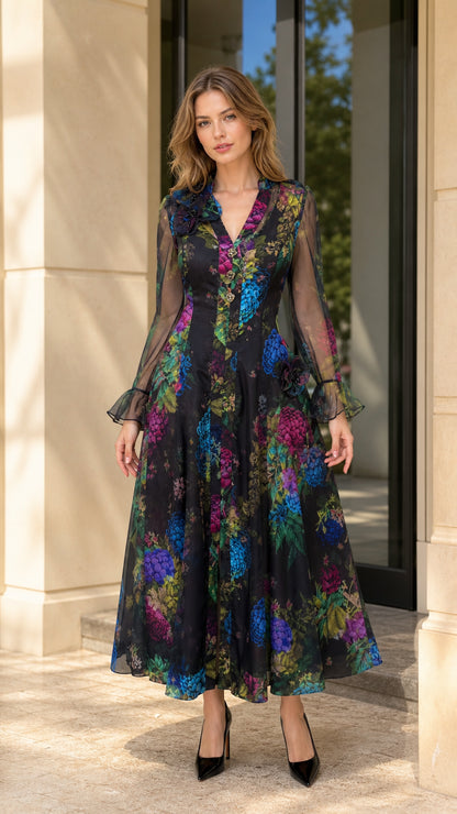 Full front view of model wearing black floral print maxi dress with long sheer sleeves
