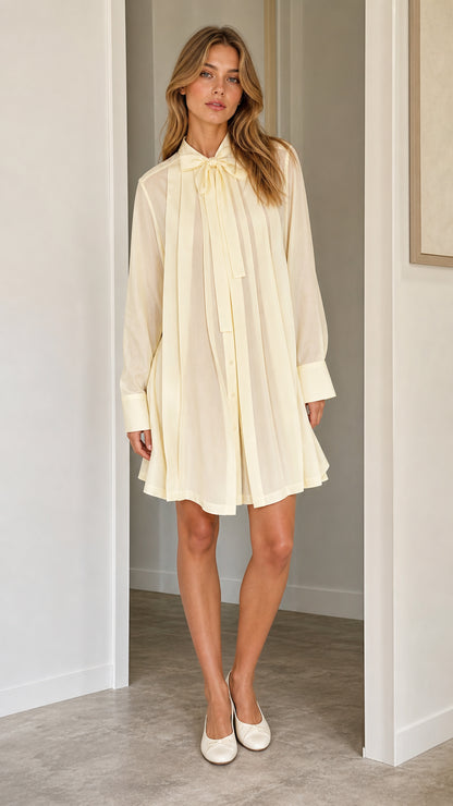 Front full view of cream pleated tie-neck shift dress