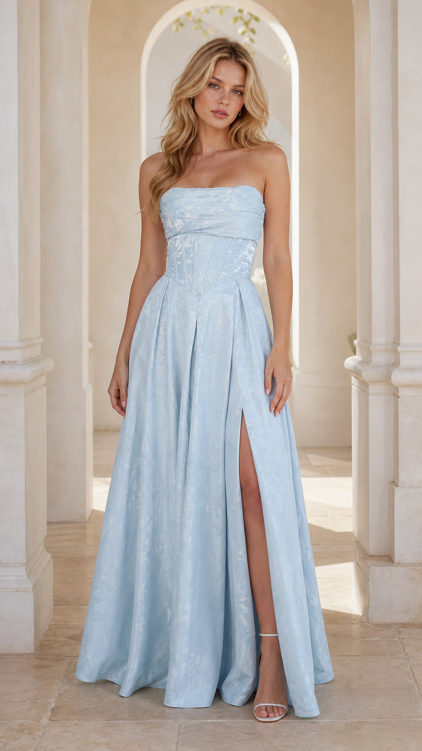 Front view of model in light blue strapless jacquard corset gown with high slit