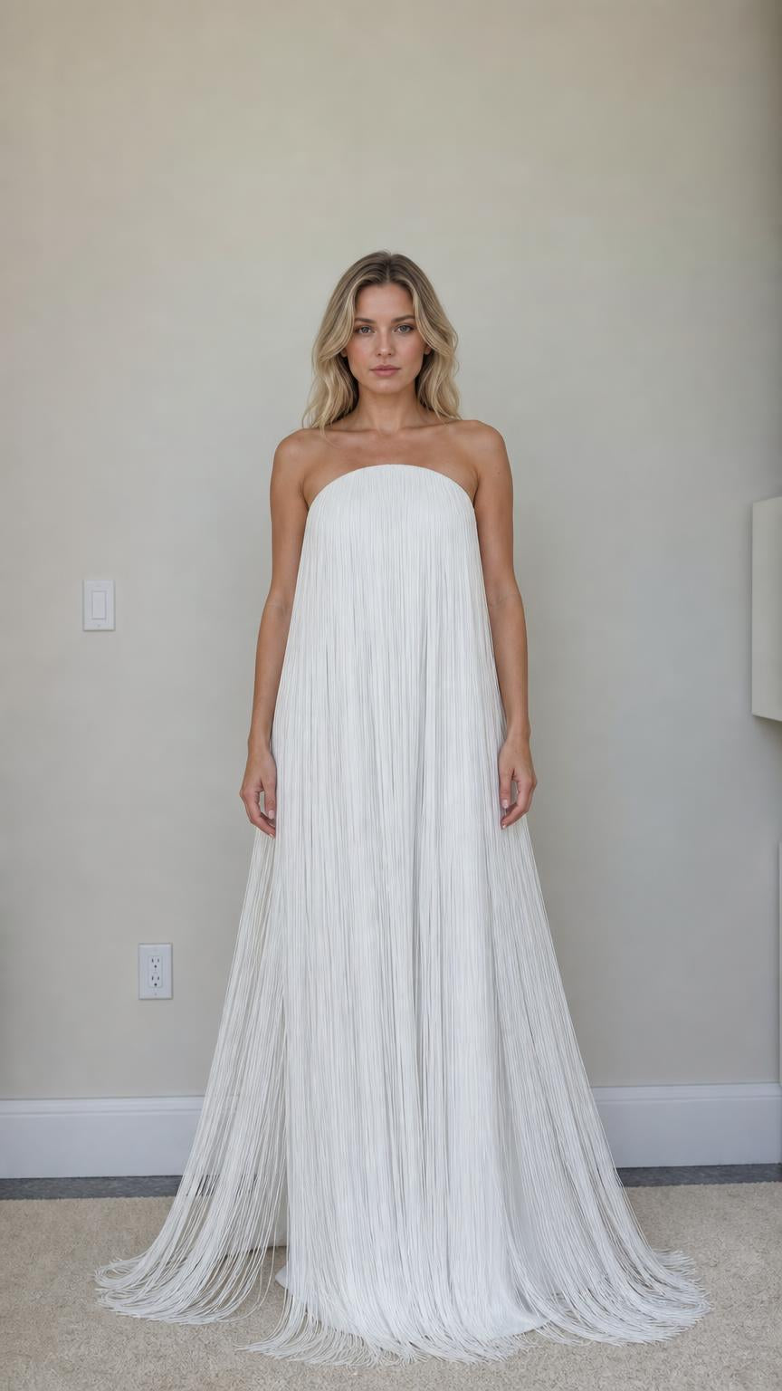 Front view of woman wearing white strapless fringe maxi dress